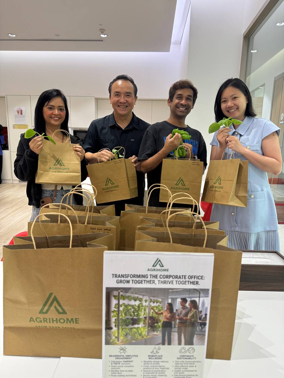 Group of happy employees holding bags of freshly harvested vegetables from their Agrihome office farm.